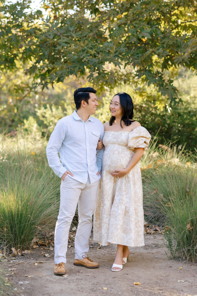 Pregnant couple standing together outdoors with simple coordinated maternity session styling