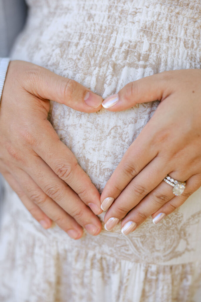 Pregnant mom forming a heart with her hands over her belly during a maternity photo session
