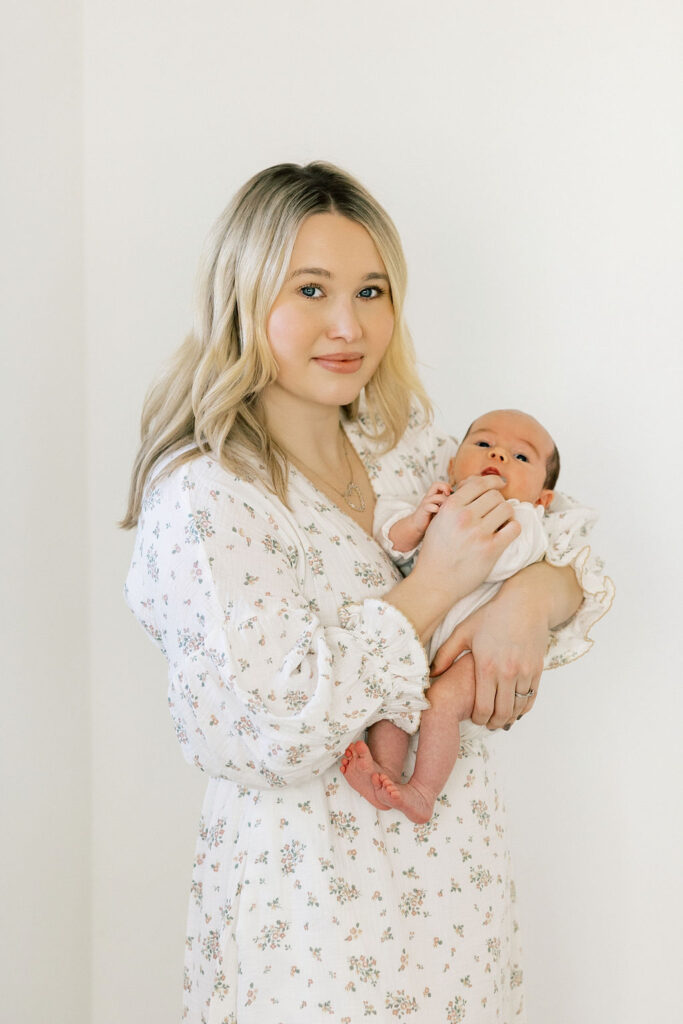 Mother holding her newborn baby during a light and airy lifestyle session