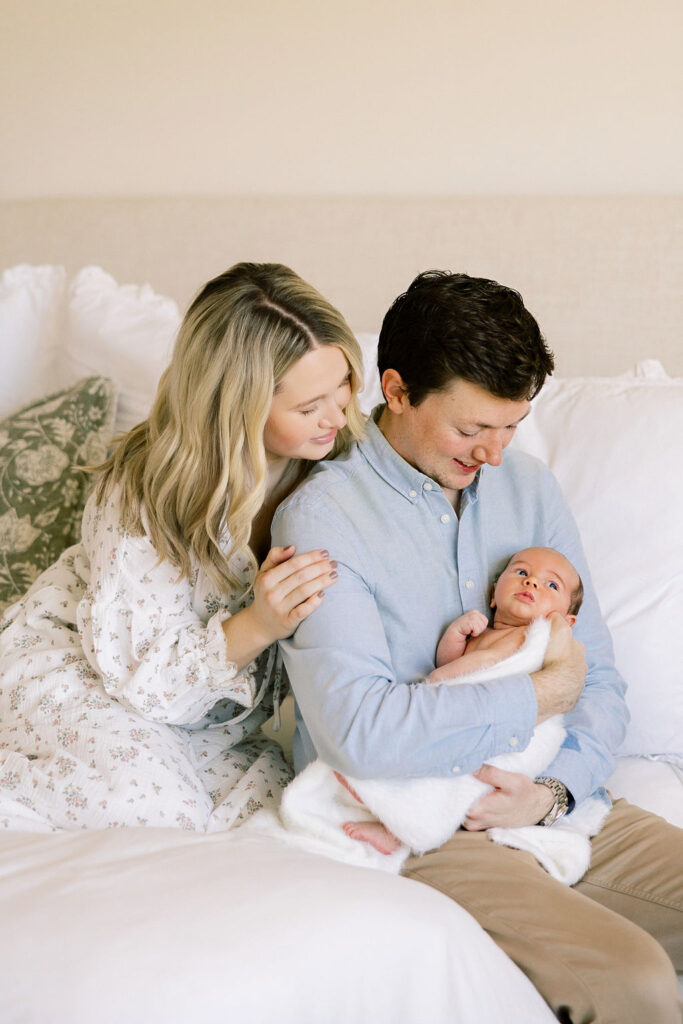 Parents cuddling their newborn during a warm and natural family photography session