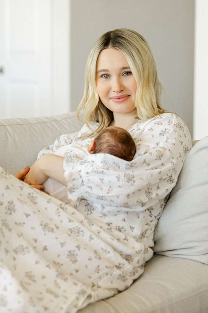 Mom holding her newborn in a light neutral outfit for newborn photos