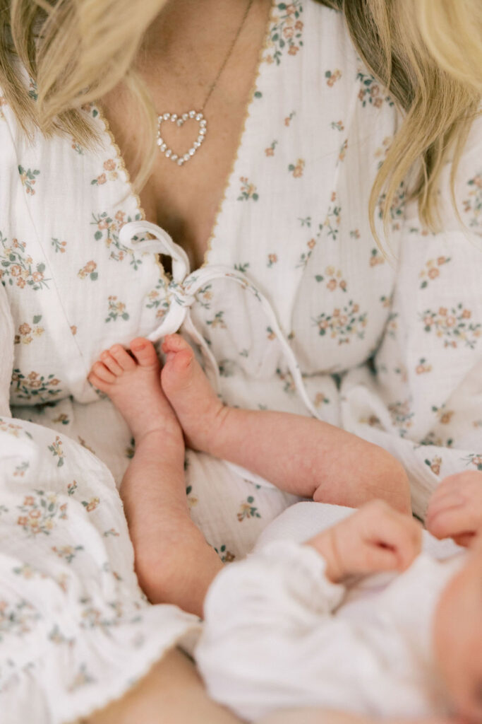 Newborn baby resting against mom’s soft floral dress, showing a light neutral outfit idea for newborn photos in Santa Clarita
