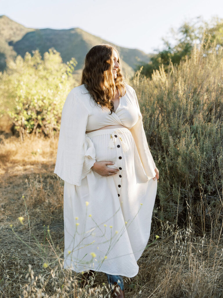 When to Take Maternity Photos with a close up of a pregnant woman gently cradling her baby bump during a Santa Clarita maternity session