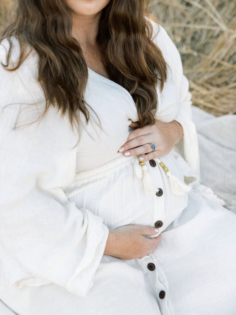 Close up of a pregnant woman gently cradling her belly during a Santa Clarita maternity session