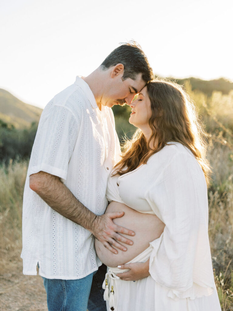 Close up of expecting couple sharing a tender moment outdoors