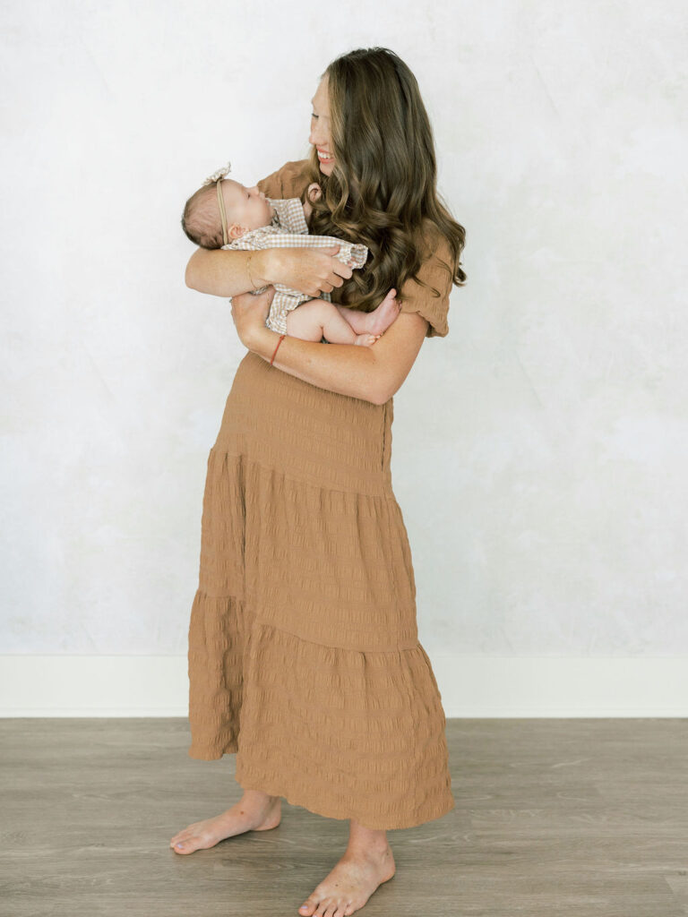 Mom standing and gently rocking her newborn baby during a Santa Clarita newborn session