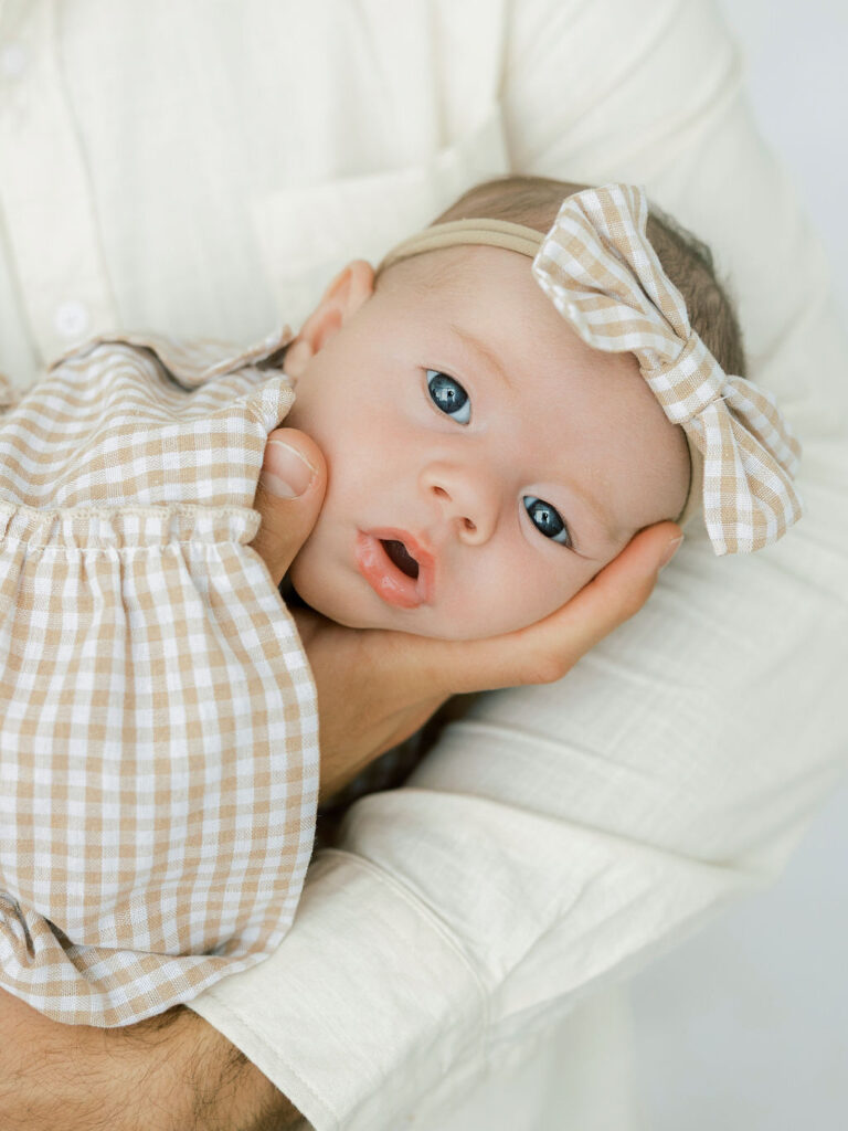 Newborn baby resting against mom during a natural studio newborn session