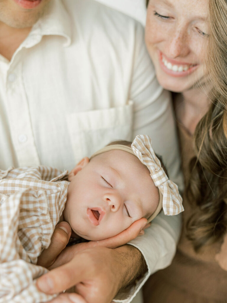 Mom smiling down at her newborn baby during a relaxed studio session