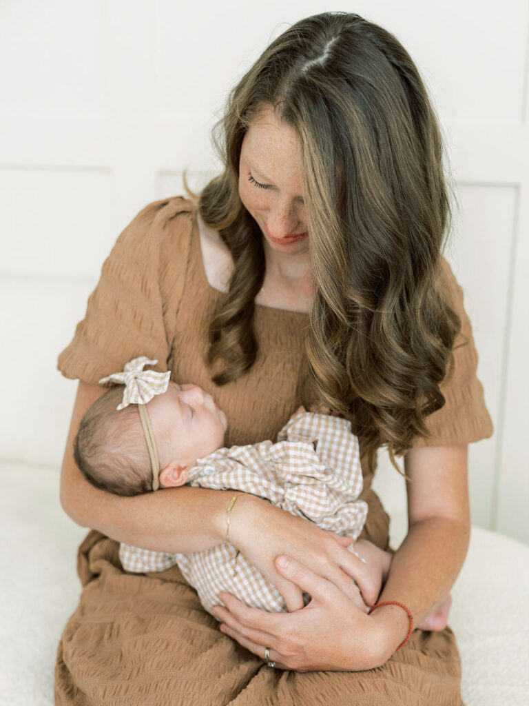 Mom looking down at her newborn baby during a studio newborn photography session in Santa Clarita