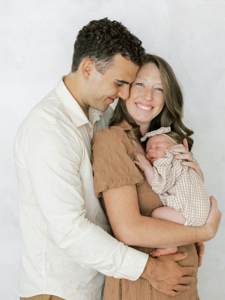 Parents cuddling their newborn baby during a relaxed Santa Clarita newborn photo session