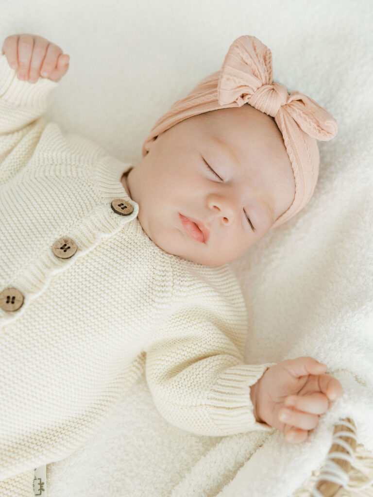 Newborn baby lying on a soft white blanket during a studio newborn photography session in Santa Clarita