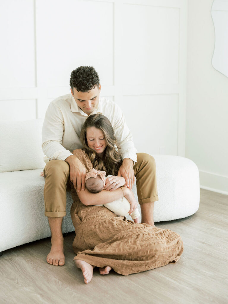 Parents seated together with their newborn baby during a relaxed Santa Clarita studio newborn session